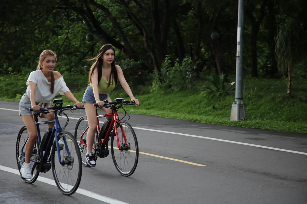 兩位女生在河濱騎電輔車