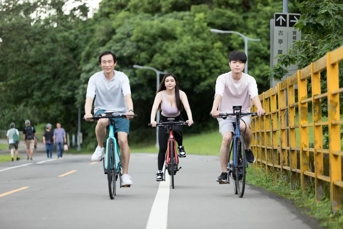 三人沿河濱車道並排騎車